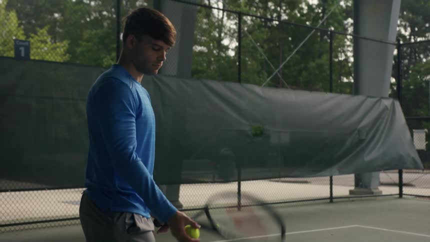 A man hits a tennis ball on the court