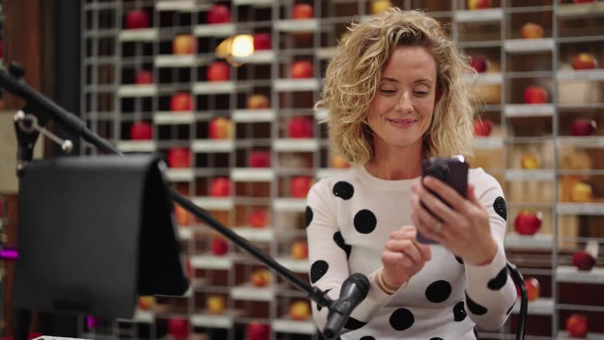 A keyboardist waves goodbye to someone during a video call on her phone