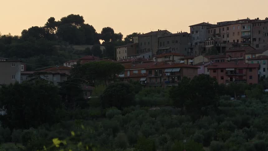 Apartment buildings sit on a hill overlooking a field