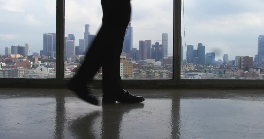 A person is walking in a building in a downtown city