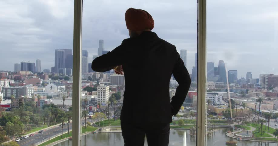 A man checks his watch while looking at the skyline