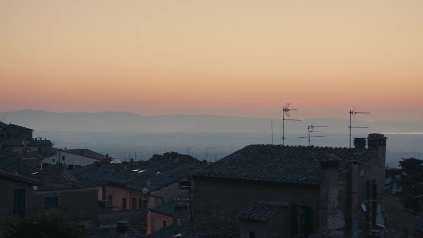The sun is setting in a neighborhood near the coast