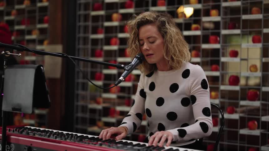 A woman plays a keyboard and sings