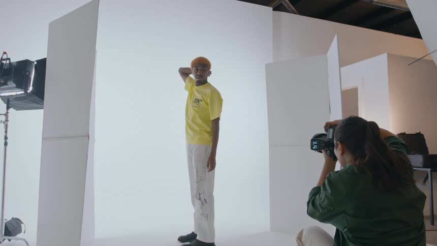 A photographer takes photos of a man during a photo shoot