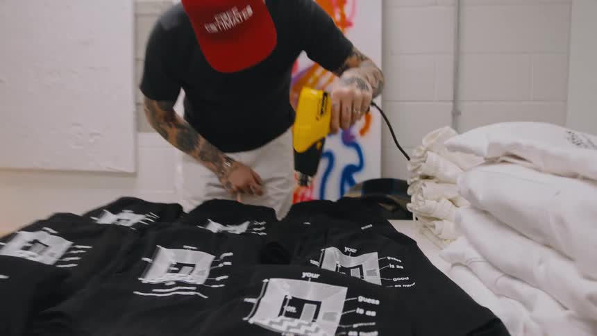 There is a man that is drying clothes inside of a building