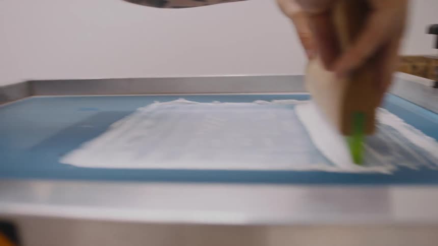A man screen prints a t shirt