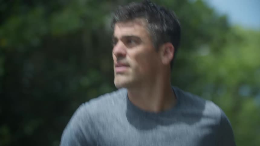 Man with graying hair looks around while jogging