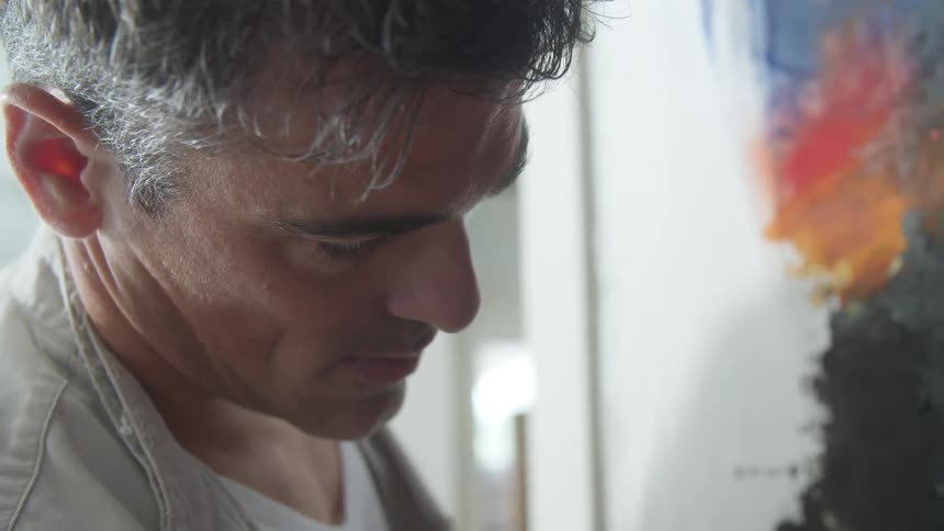 A man paints on a canvas