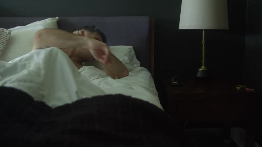 A man checks his phone after struggling to wake up