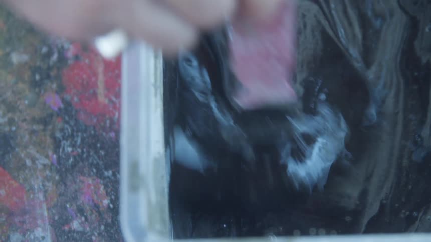 Close up of a person stirring paint