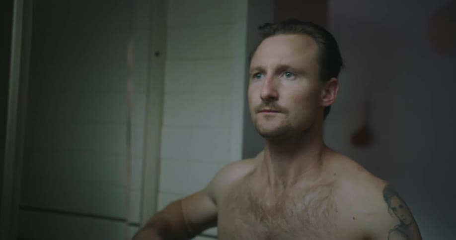 Man drying face with towel in bathroom