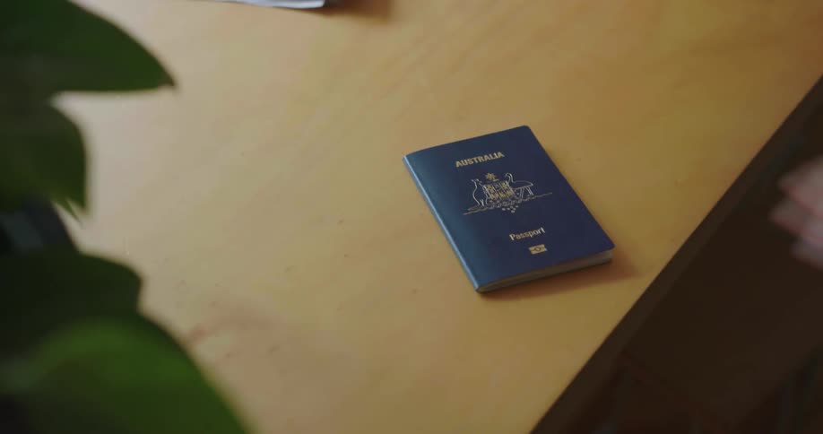 A man grabs keys and a passport from a table