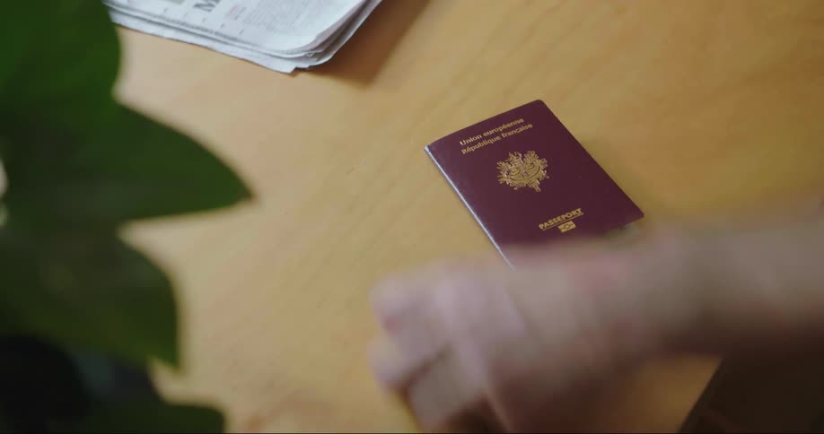 Person grabs keys and a passport off a table