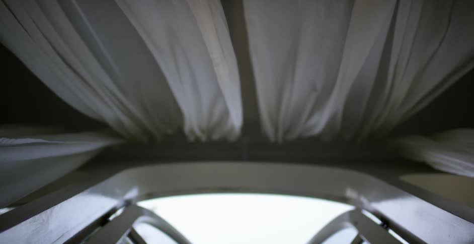 The curtains blow in the wind of this window