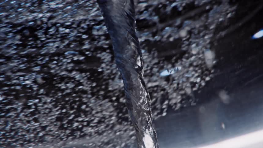A vortex of liquid is swirling down the middle with bubbles all around it