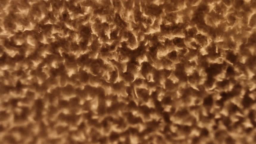 A rough splashing gold substance moves as it intensely vibrates and changes shape