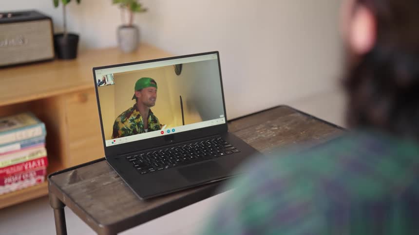 Someone is video chatting with a friend on there laptop inside of there room