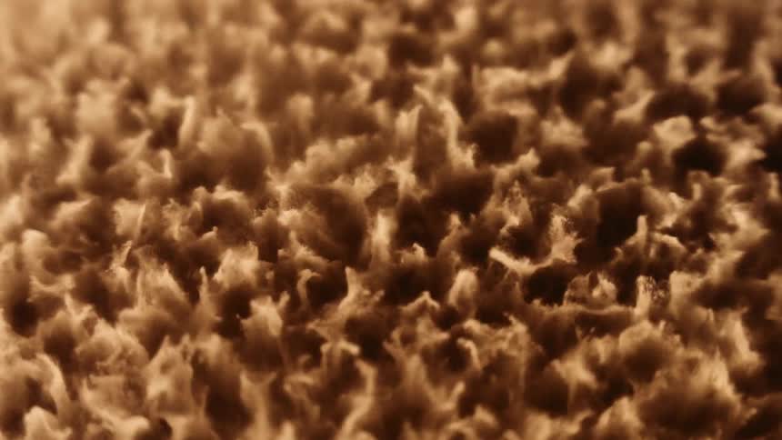 A rough splashing gold substance moves as it intensely vibrates and melts