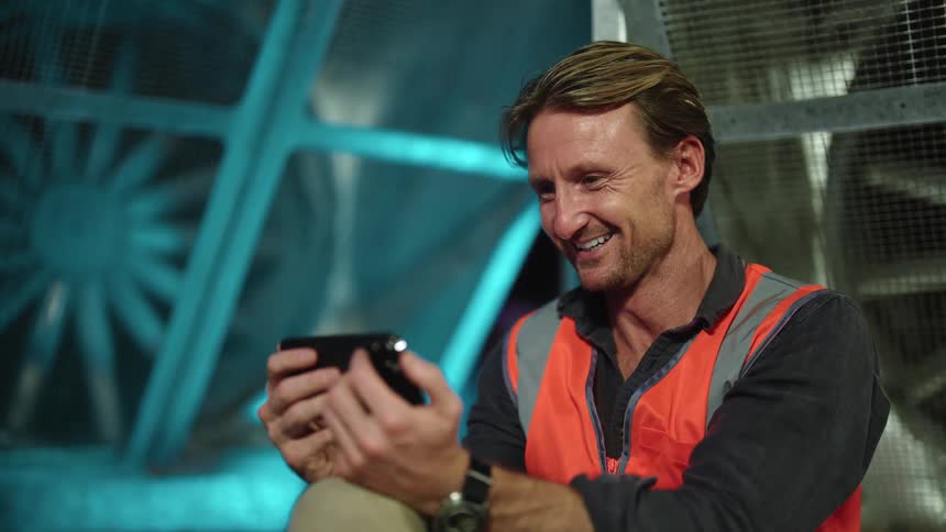 A man working on a construction site with a phone