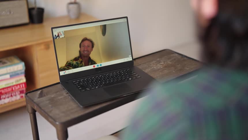 Two men happily video chatting from a living room