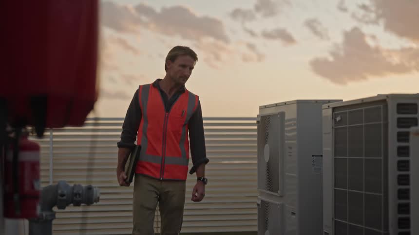 A man is checking the hvac units