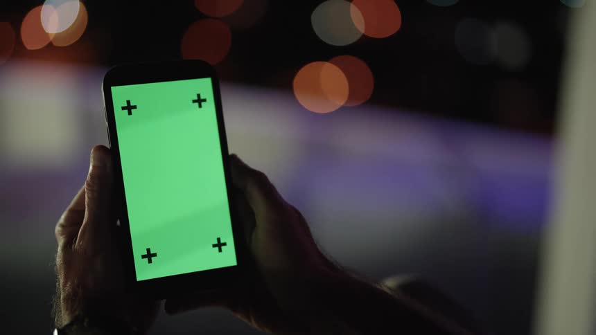 A mans hands are shown holding a smartphone and flicking up on the screen with his thumb