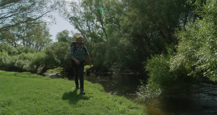A young man is walking outside in the nature area