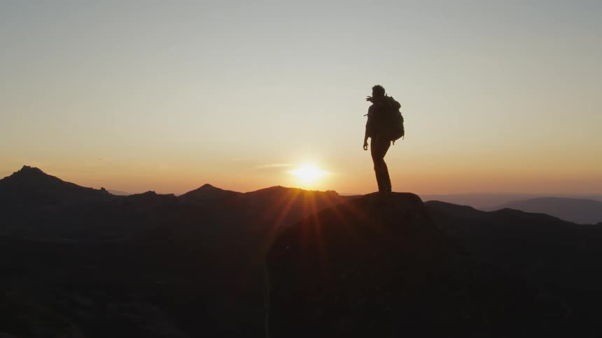 A hiker is watching the sunrise on the mountain
