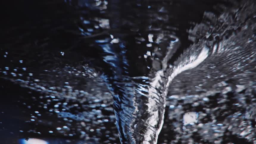 A funnel of swirling water is seen from below the surface