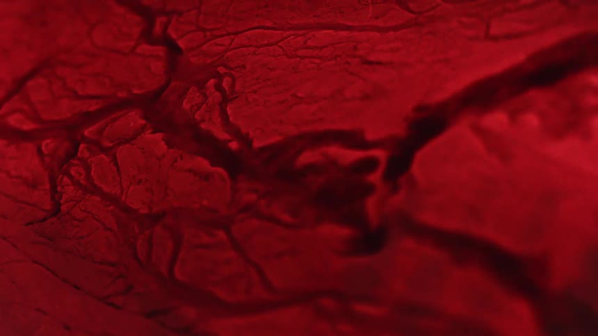 Red cracked surface objects break apart as water ripples and moves through the liquid