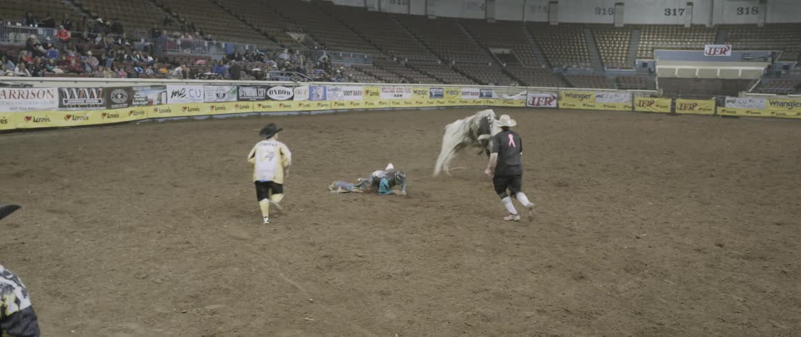 A rodeo cowboy rides a bucking bull