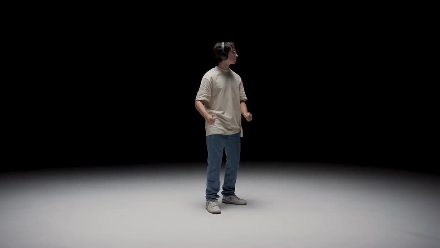 A young teenager is standing and listening to music