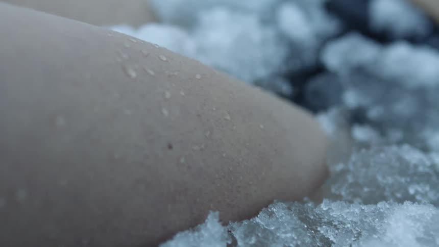 Goosebumps and water drops on a person submerged in ice and snow covered water