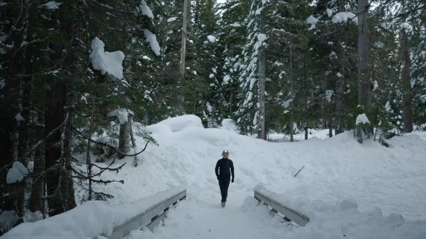 A woman walking in a snow covered forest