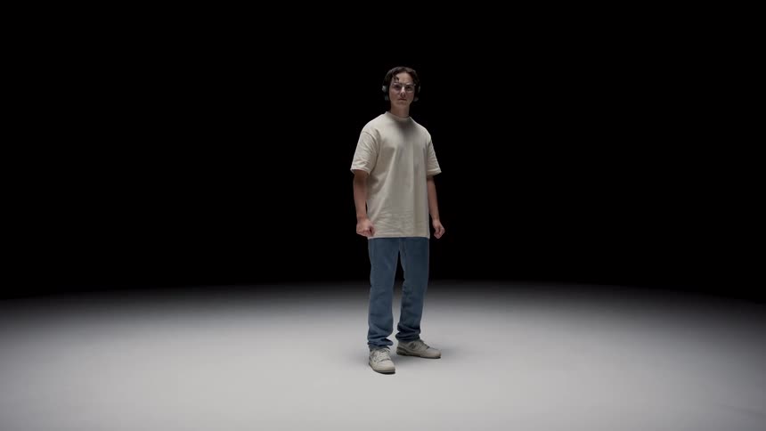 A young teenage boy is standing inside of a room
