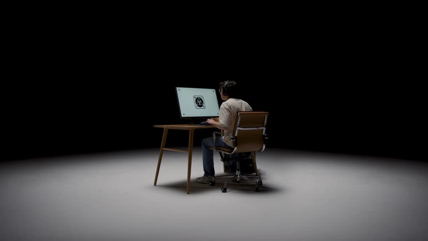 A young teenage boy is sitting down and is on his laptop
