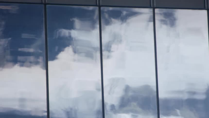 Floating white clouds reflected on building windows