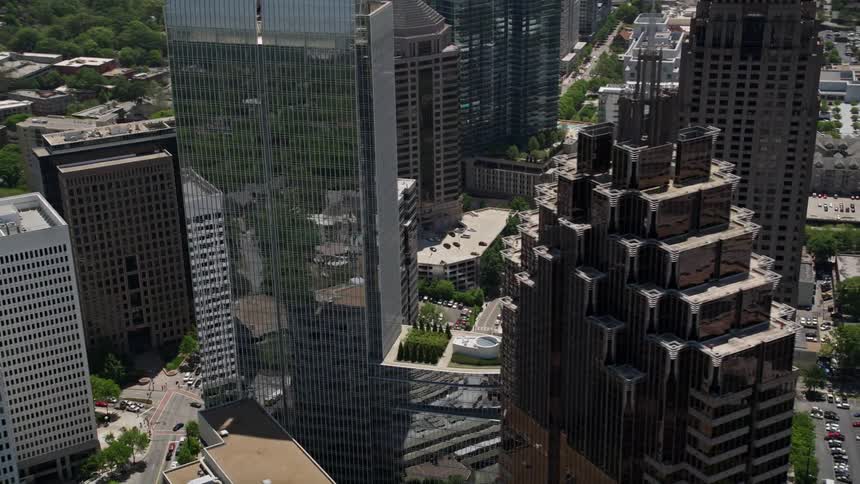 A side view aerial footage of Promenade II revealing 1180 Peachtree and other modern skyscrapers in Midtown Atlanta on a sunny day