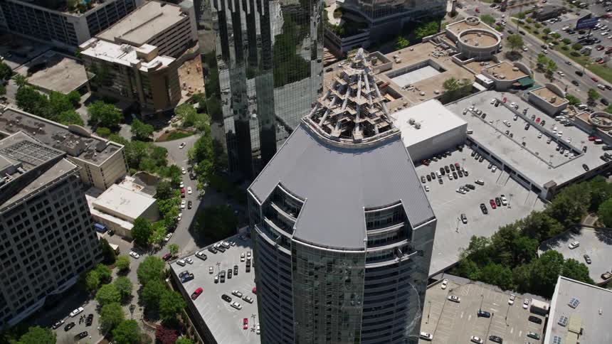 Aerial view approaching and tilting down to birds eye of Buckhead Grand a modern skyscraper in Atlanta Georgia