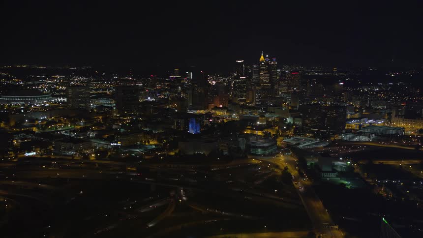 Aerial footage of Turner Field and downtown Atlanta skyline at night tilting down to reveal the towering skyscrapers and cityscape below