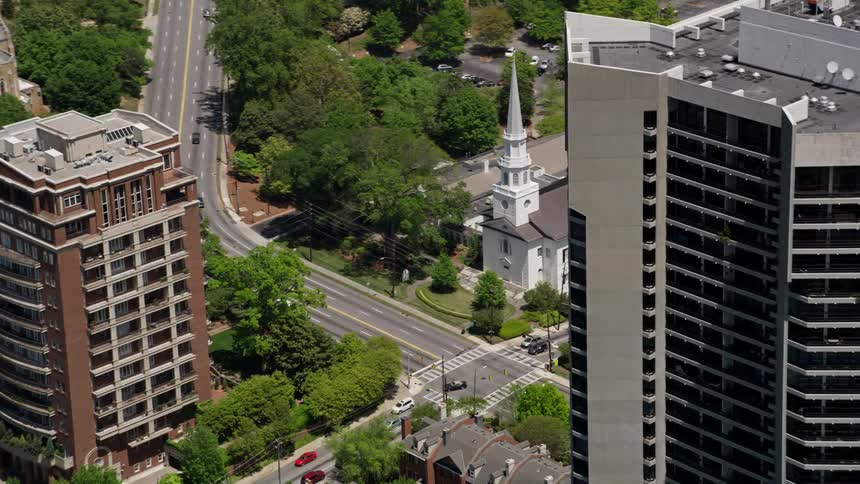 Approaching a high-rise condominium in Buckhead Georgia this aerial footage captures a stunning reveal of a beautiful church nestled among the residential buildings