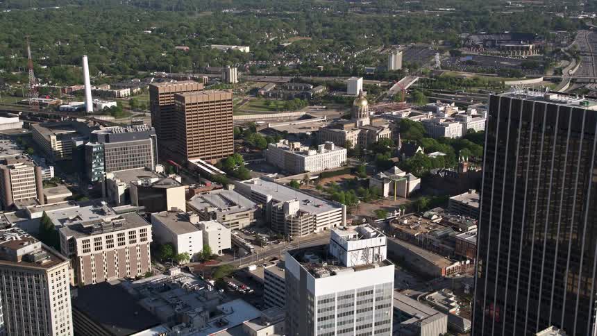 Fly over of Downtown Atlanta approaching Georgia State Capitol among office buildings on a sunny day