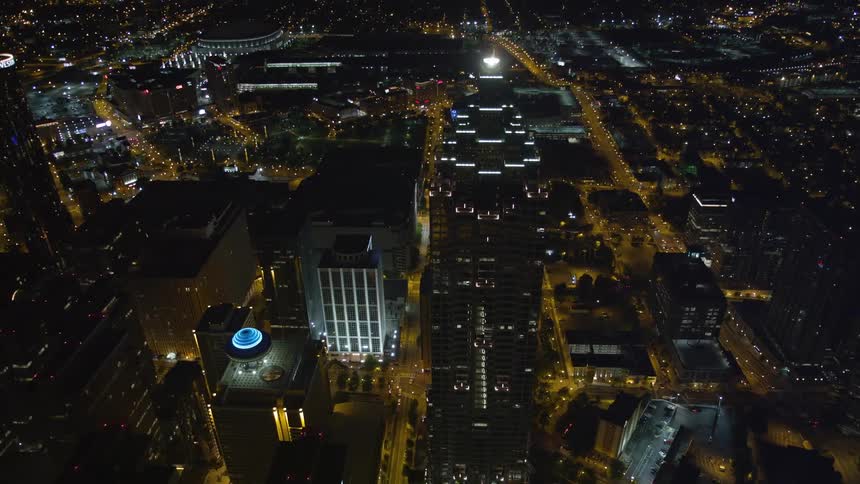 Approaching SunTrust Plaza in Downtown Atlanta by night with a spectacular birds eye view of the city streets as the camera tilts down