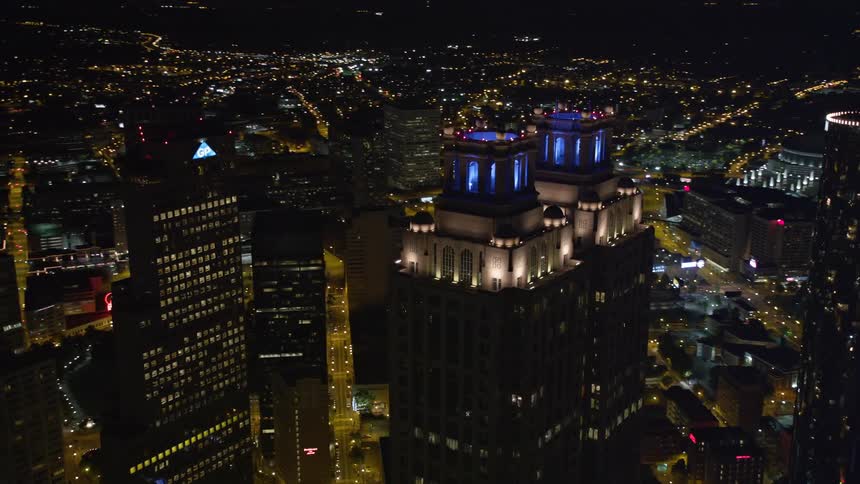 Aerial footage of downtown Atlanta Georgia at night featuring skyscrapers including the 191 Peachtree Tower and the Westin Peachtree Plaza Hotel as well as clear skies and an orbiting 