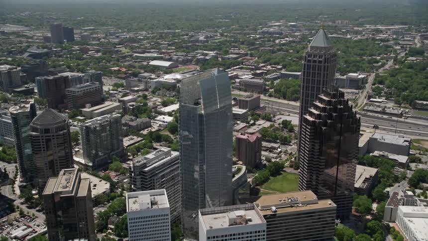 Aerial footage of high-rise buildings in Atlanta Georgia with a tilt revealing Midtown and Downtown skyscrapers during the daytime