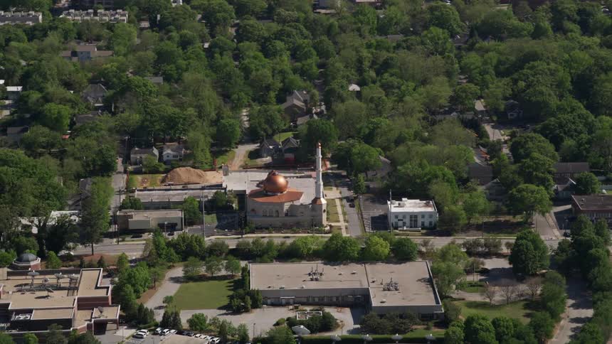 A stunning aerial view of Al-Farooq Masjid Atlanta Georgia amidst a green landscape with a classic-looking architectural structure comprising copper domes and a white minaret tower