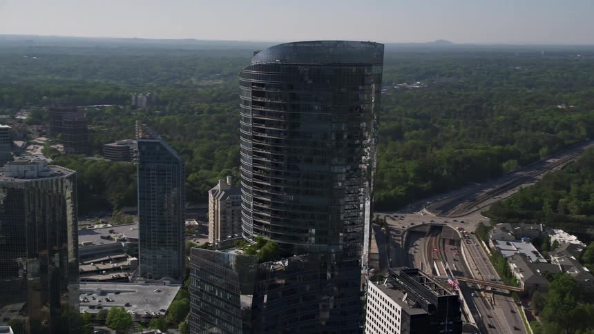 An aerial orbit of 3344 Peachtree Road skyscraper in Buckhead Georgia showcasing its modern glass building design and surrounding high rise buildings