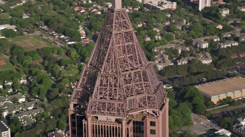 A stunning aerial footage showing a close-up orbit of the top of Bank of America Plaza a high-rise skyscraper in Midtown Atlanta during the daytime