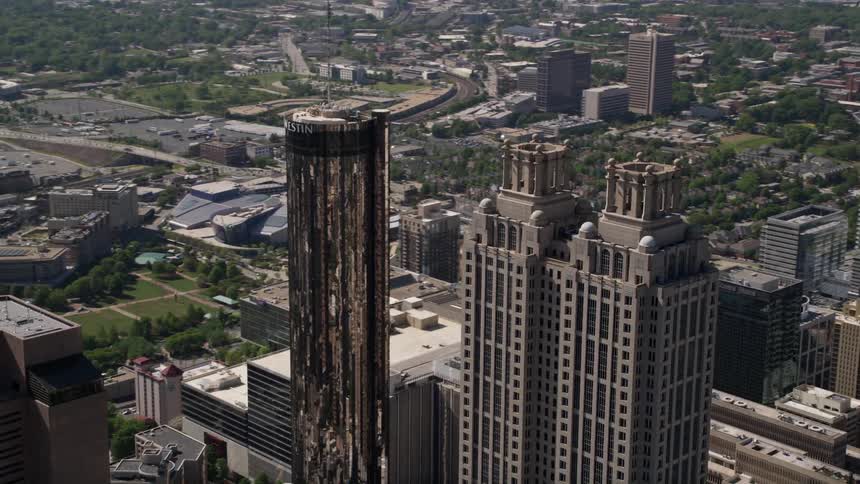 A breathtaking aerial view of Downtown Atlantas iconic Westin Peachtree Plaza and 191 Peachtree Tower orbit revealing the citys beautiful skyline and bustling metropolis during a sunny day
