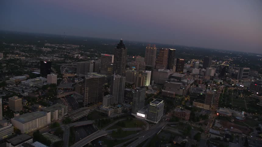Approaching Downtown Atlanta skyscrapers at sunset via aerial view from Midtown